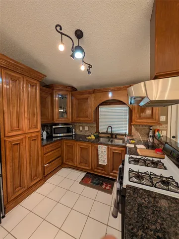 a kitchen with stainless steel appliances granite countertop a stove a sink and a refrigerator