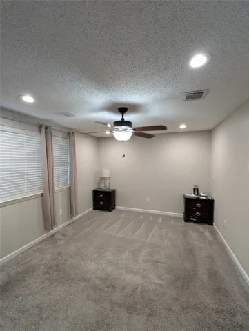 an empty room with windows and fan