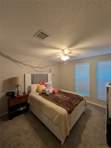 a bedroom with a bed and a ceiling fan
