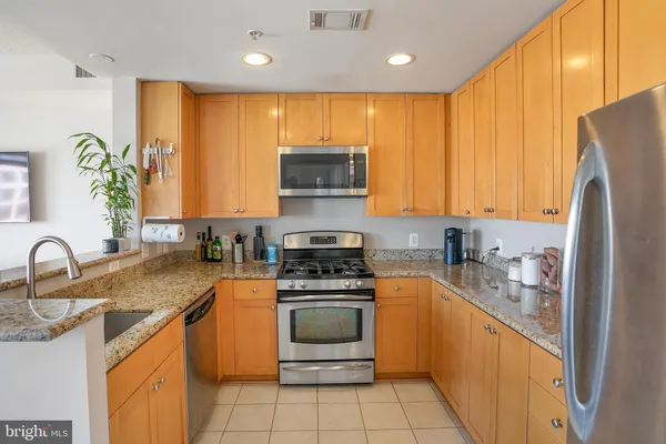 a kitchen with stainless steel appliances a stove a sink a microwave a refrigerator and cabinets