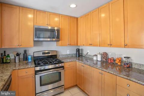 a kitchen with stainless steel appliances a stove a sink and white cabinets