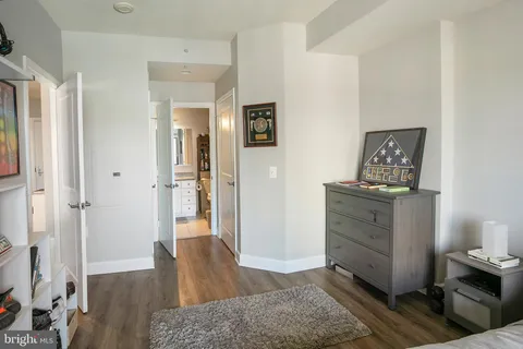 a view of a hallway to a livingroom with wooden floor and cabinet