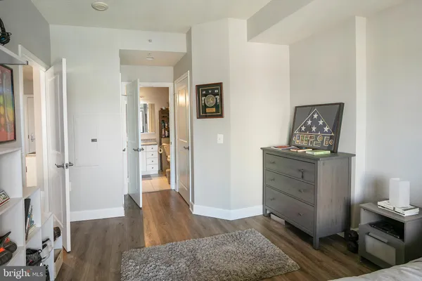 a view of a hallway to a livingroom with wooden floor and cabinet