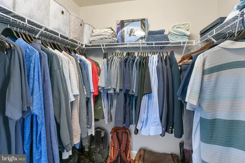 a view of walk in closet with clothes and shoes