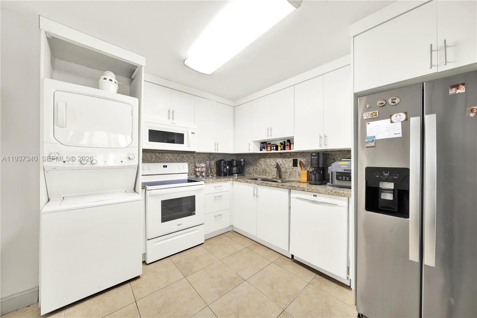 1901 Brickell Avenue, Unit B711 Miami, FL 33129 - Photo 12 of 41 a kitchen with white cabinets and white appliances