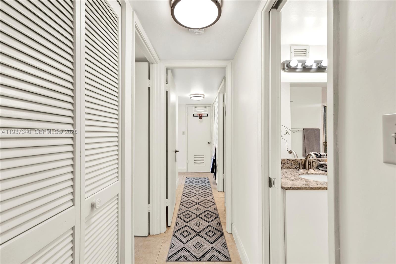 1901 Brickell Avenue, Unit B711 Miami, FL 33129 - Photo 13 of 41 a bathroom with a granite countertop sink and a mirror