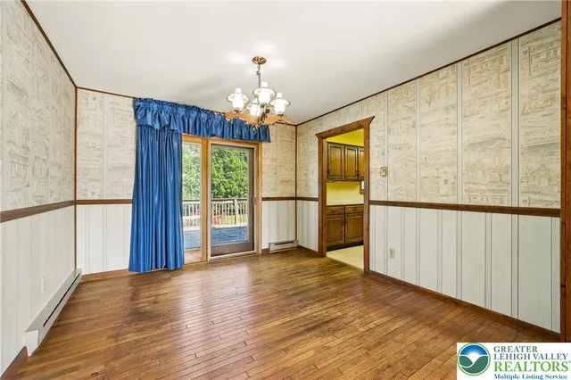 a view of a big room with wooden floor and chandelier