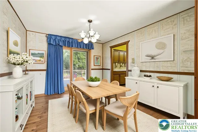 a dining room with wooden floor a chandelier a wooden table and chairs