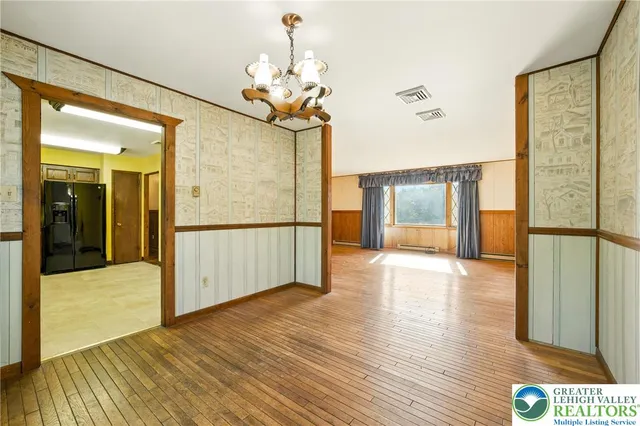 a view of a hallway with wooden floor and glass door