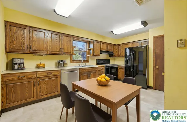 a kitchen with a refrigerator a stove a sink dishwasher and wooden cabinets with wooden floor