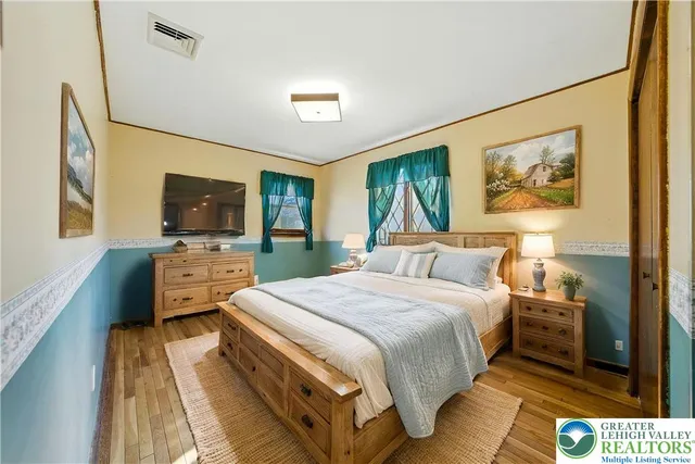 a bedroom with a bed and wooden floor