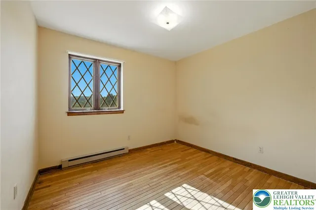 a view of an empty room with a fireplace and a window