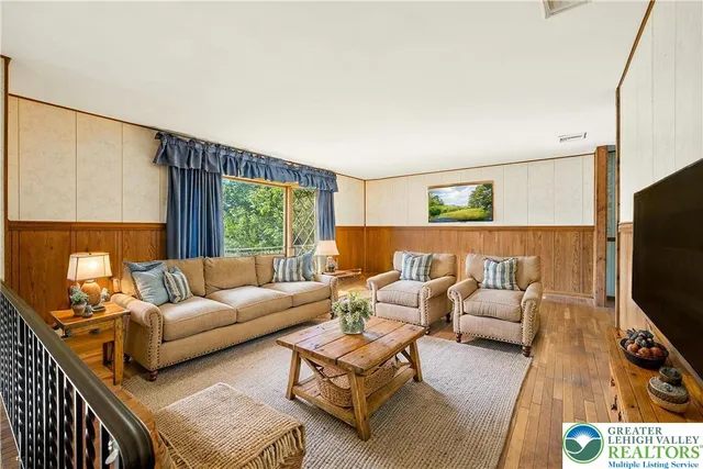 a living room with furniture flat screen tv and window