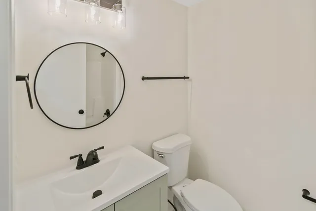 a bathroom with a sink a toilet and a mirror