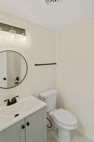 a bathroom with a sink toilet and mirror