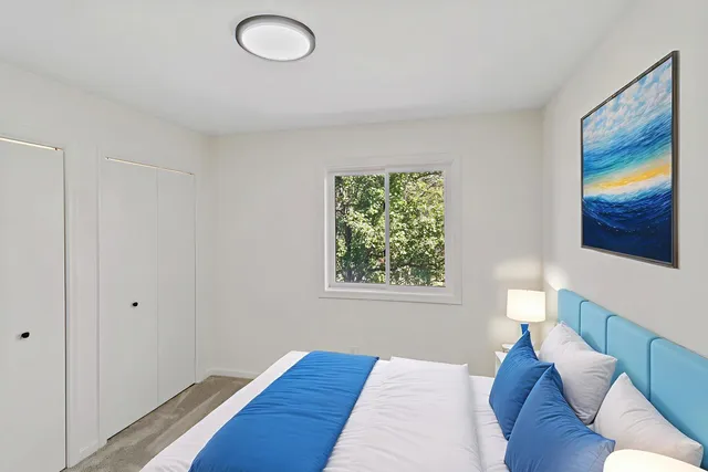 a bedroom with a bed and a painting on the wall