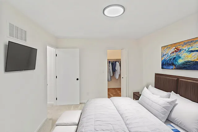 a bedroom with a bed and a flat screen tv