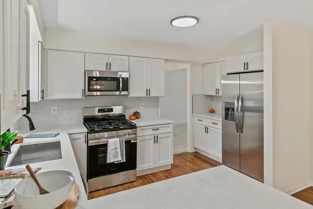 a kitchen with stainless steel appliances a stove a refrigerator and a sink