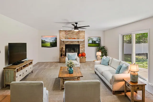 a living room with furniture a fireplace and a flat screen tv