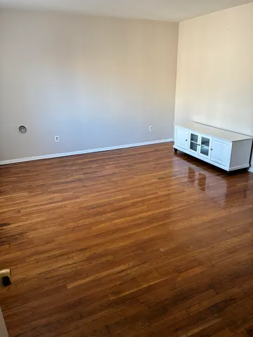 a view of a room with wooden floor and a window