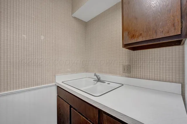 a view of an empty room with a fireplace and a window