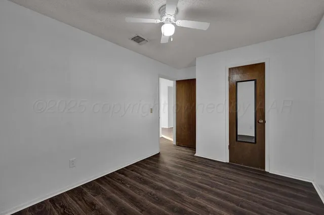 a view of empty room with wooden floor