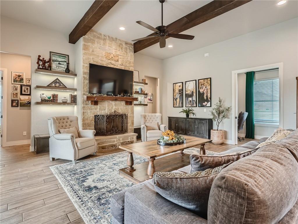132 Huerta Road Florence, TX 76527 - Photo 5 of 40 Exposed wood beams add architectural interest to this inviting living room, featuring a stone fireplace.