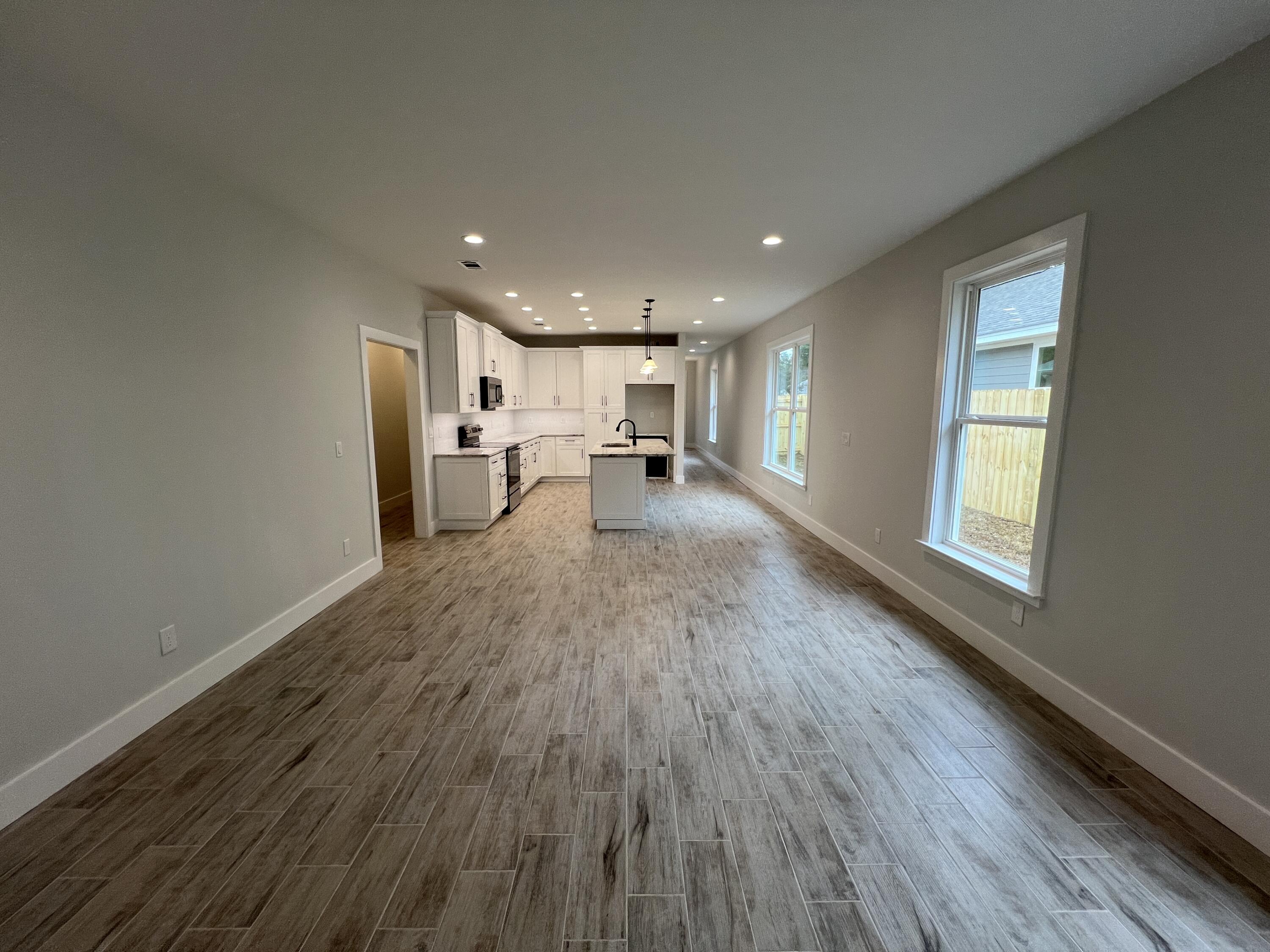 1491 Cat-Mar Road Niceville, FL 32578 - Photo 13 of 30 a view of a big room with wooden floor and windows