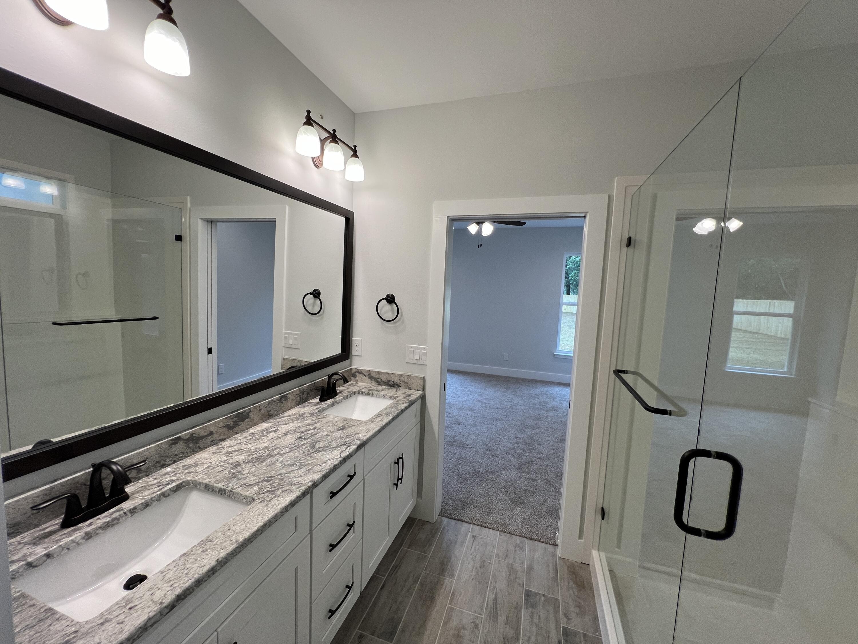 1491 Cat-Mar Road Niceville, FL 32578 - Photo 19 of 30 a spacious bathroom with a granite countertop sink a mirror and a shower