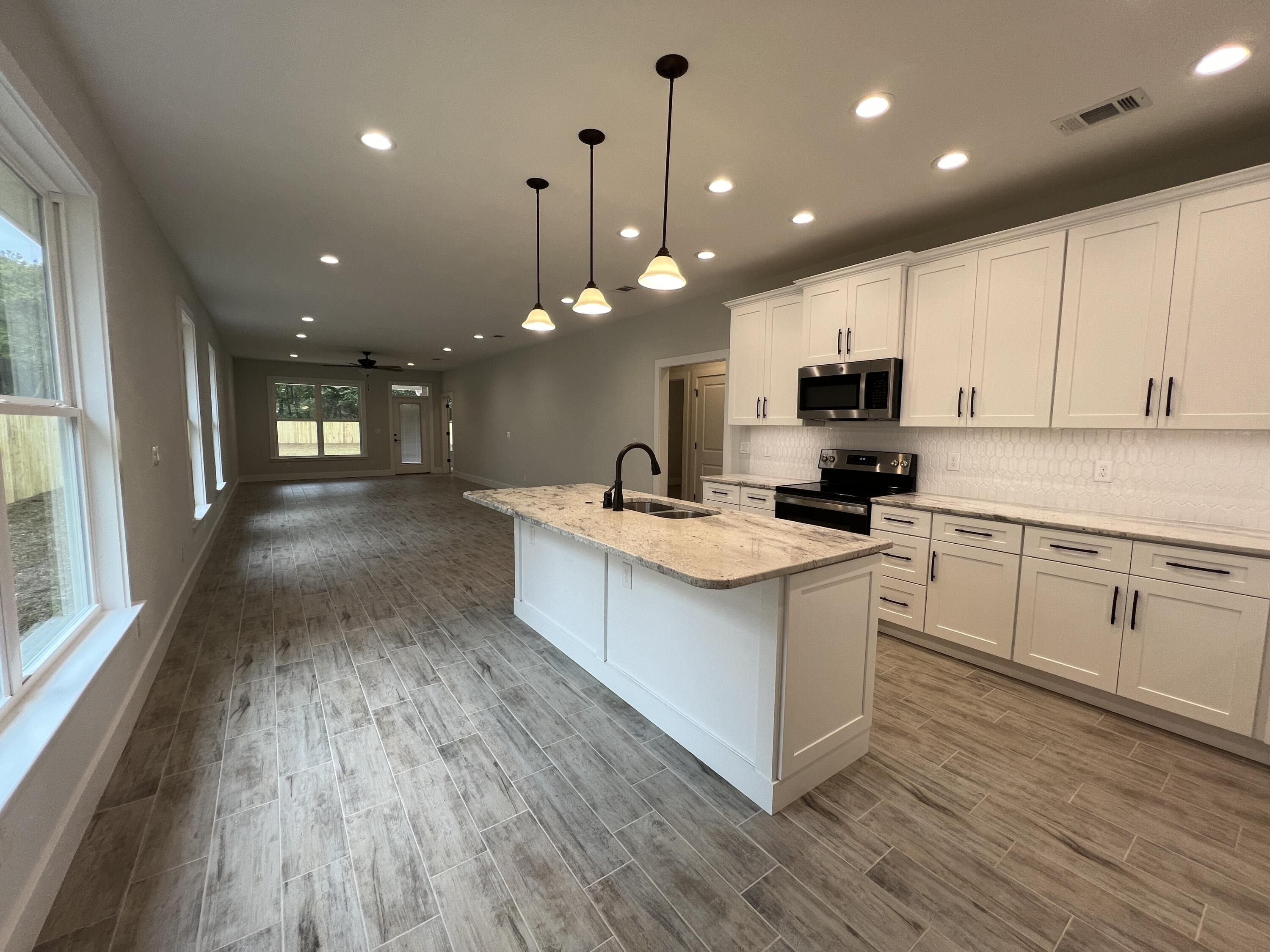 1491 Cat-Mar Road Niceville, FL 32578 - Photo 3 of 30 a large kitchen with kitchen island a sink a center island and stainless steel appliances