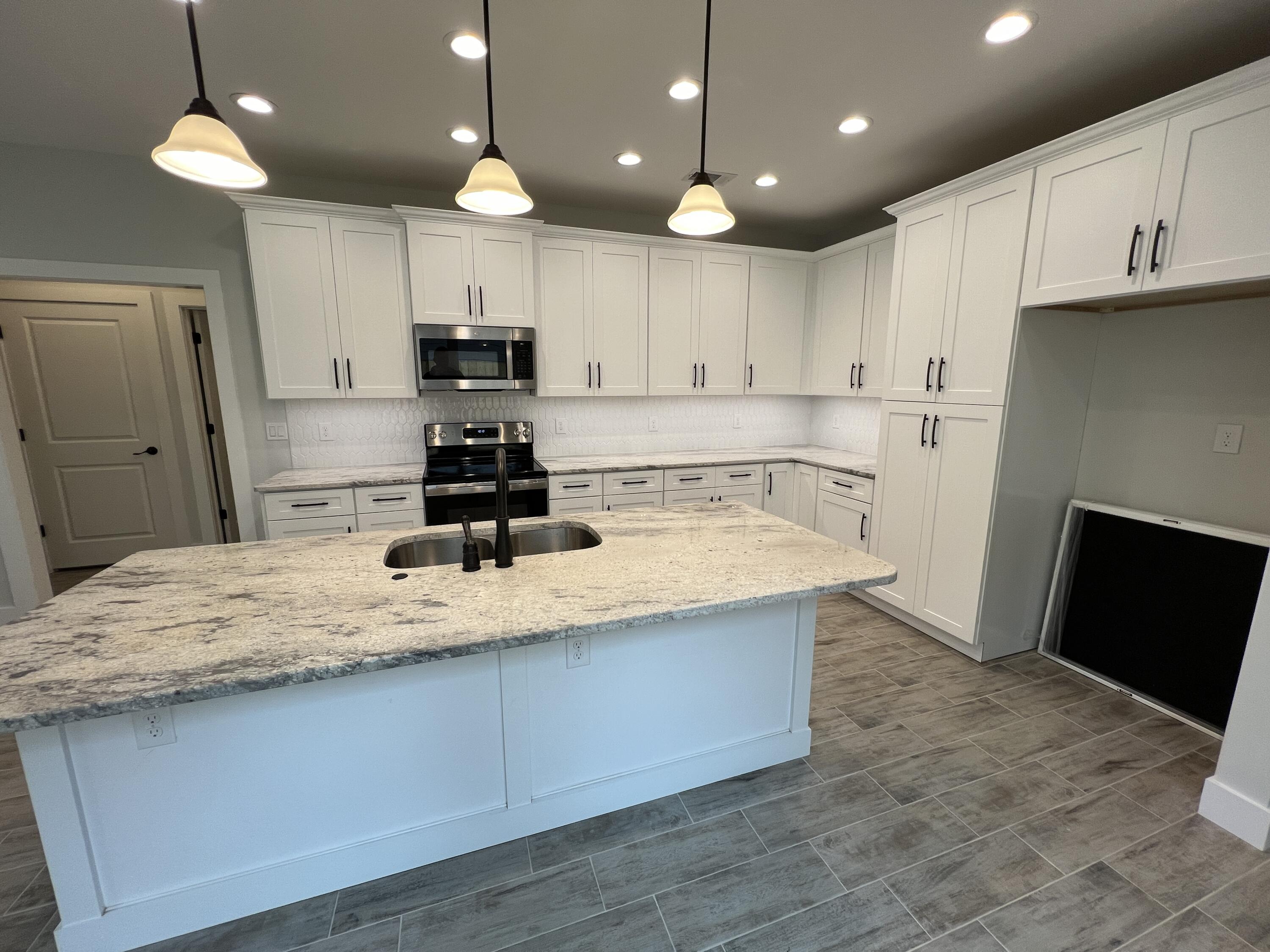 1491 Cat-Mar Road Niceville, FL 32578 - Photo 4 of 30 a kitchen with kitchen island granite countertop a stove a refrigerator a sink a microwave and wooden cabinets