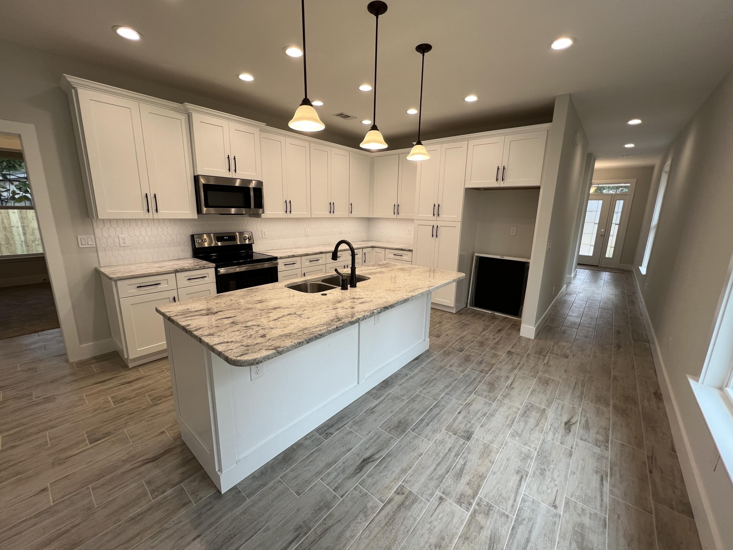 1491 Cat-Mar Road Niceville, FL 32578 - Photo 5 of 30 a large kitchen with stainless steel appliances kitchen island granite countertop a stove a sink a refrigerator and a microwave