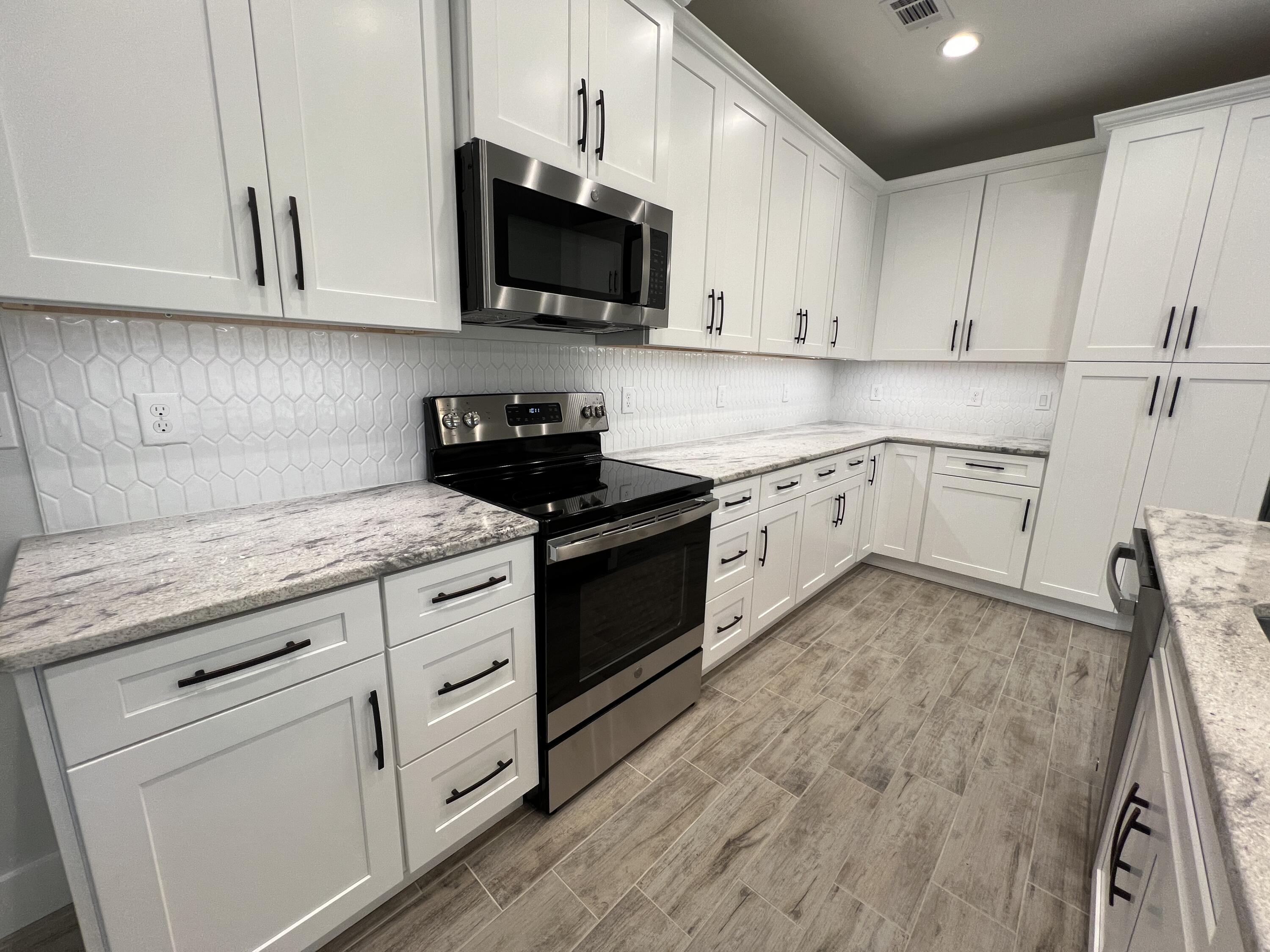1491 Cat-Mar Road Niceville, FL 32578 - Photo 7 of 30 a kitchen with granite countertop white cabinets and white appliances