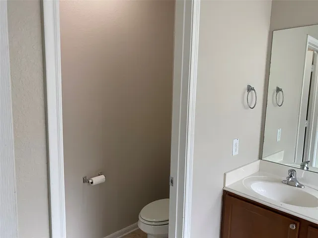a bathroom with a granite countertop sink toilet and a mirror