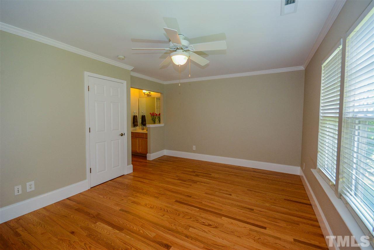 8315 Chimneycap Drive Raleigh, NC 27613 - Photo 8 of 13 an empty room with wooden floor fan and windows