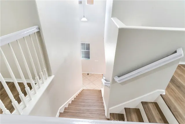 a view of a hallway with wooden floor and staircase