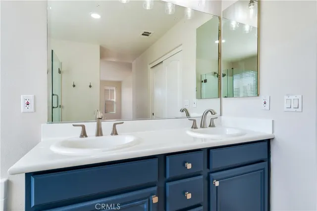 a bathroom with double sink and a mirror
