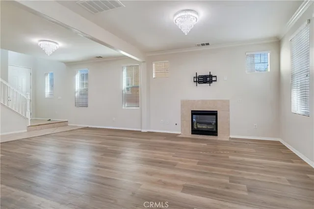 an empty room with wooden floor and fireplace
