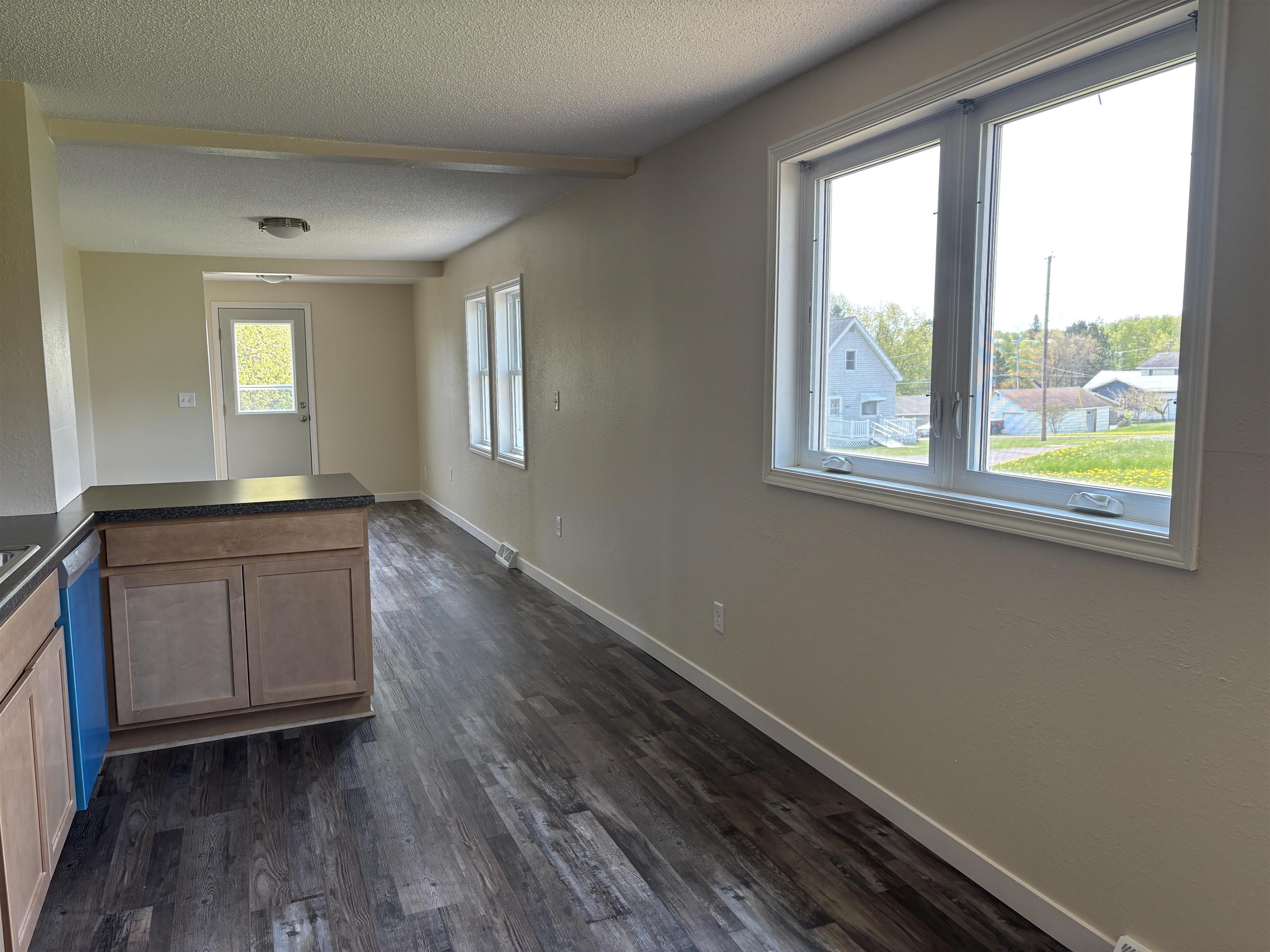 408 Midway Avenue Proctor, MN 55810 - Photo 11 of 20 Kitchen with a textured ceiling, dark countertops, dark wood-style floors, baseboards, and a peninsula