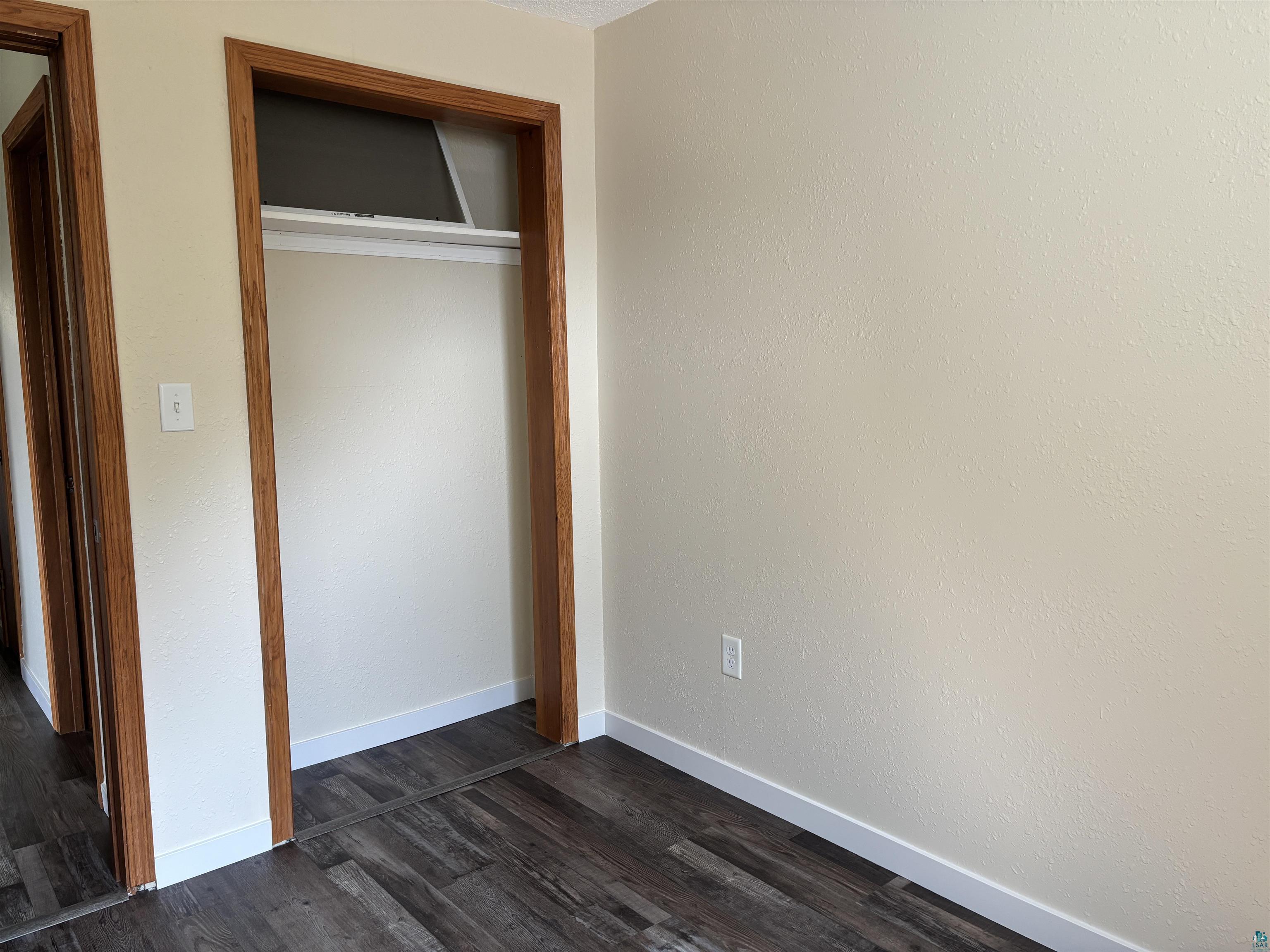 408 Midway Avenue Proctor, MN 55810 - Photo 14 of 20 Unfurnished bedroom featuring a closet, dark wood-style floors, and baseboards