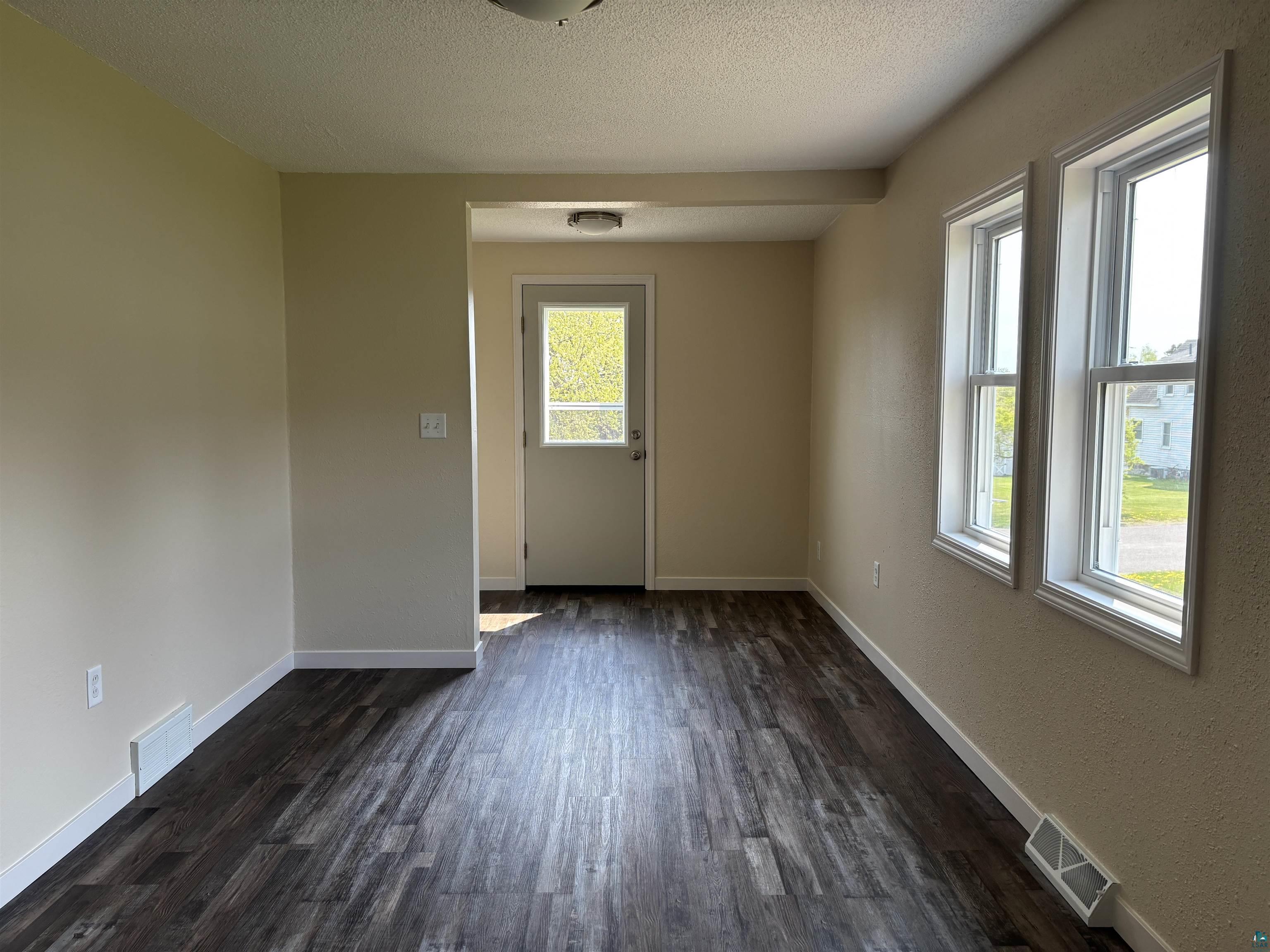 408 Midway Avenue Proctor, MN 55810 - Photo 7 of 20 Empty room with dark wood-type flooring, baseboards, and a textured ceiling
