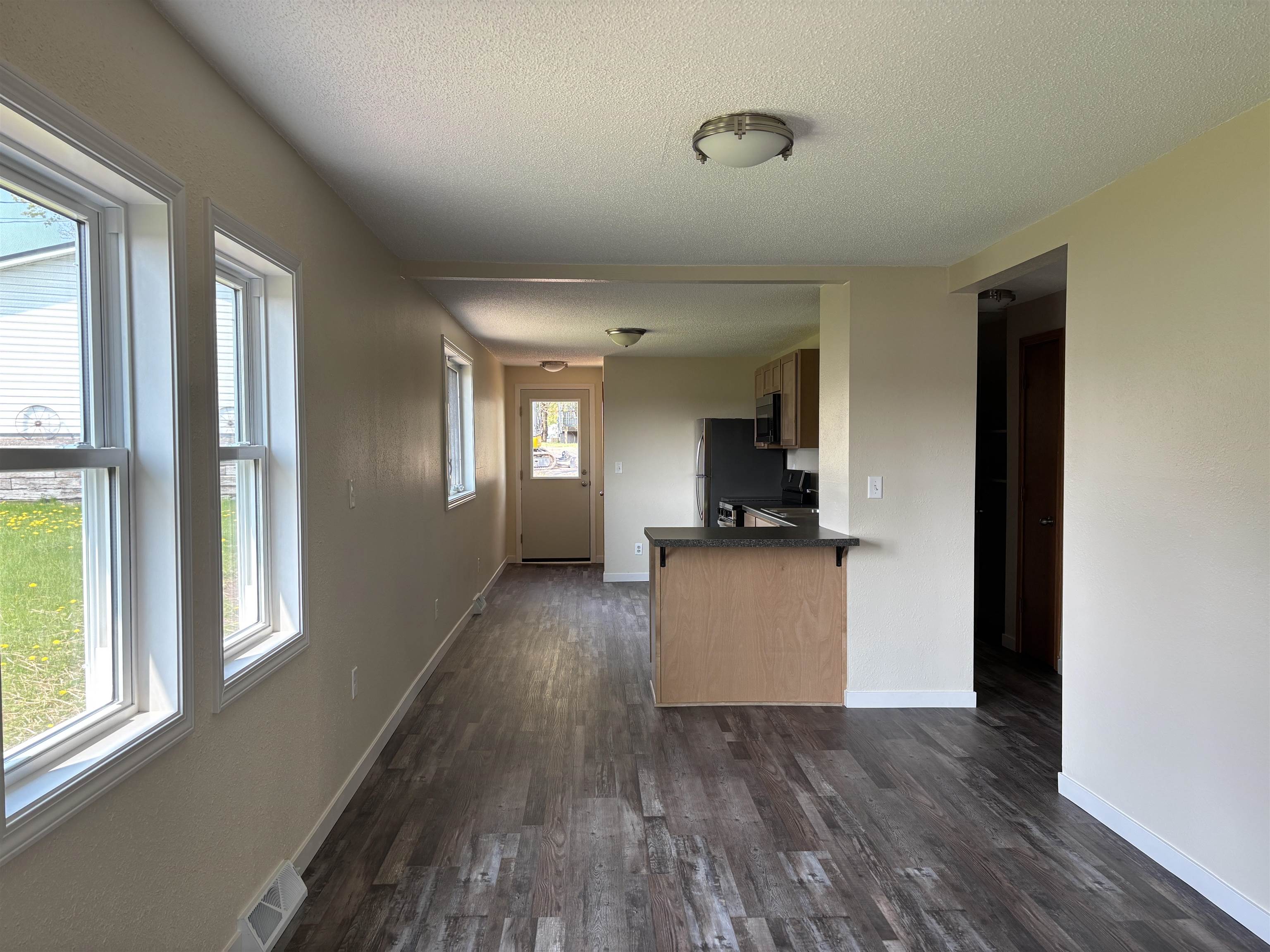 408 Midway Avenue Proctor, MN 55810 - Photo 8 of 20 Kitchen with dark wood-type flooring, freestanding refrigerator, a textured ceiling, dark countertops, and a peninsula