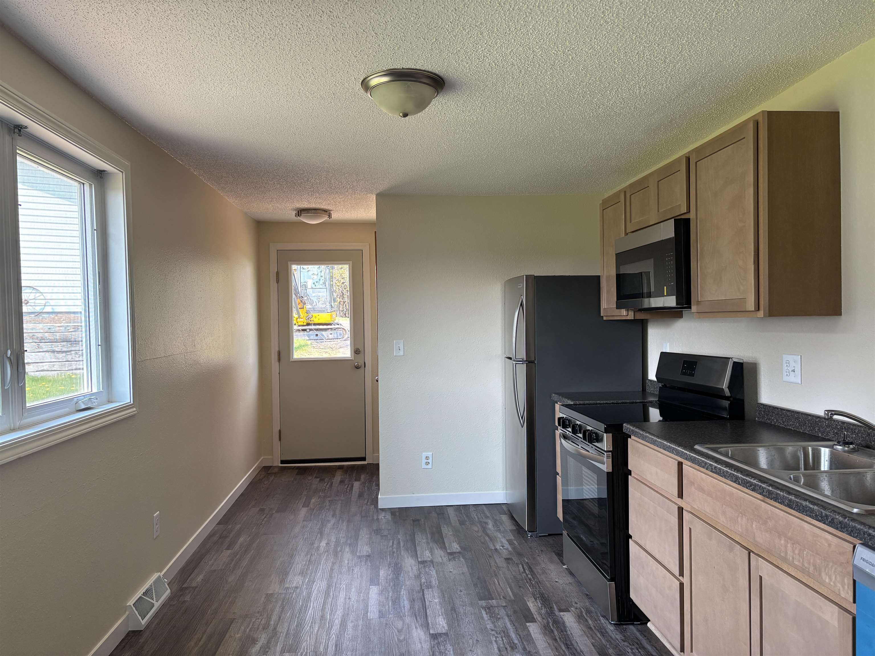 408 Midway Avenue Proctor, MN 55810 - Photo 9 of 20 Kitchen with stainless steel appliances, dark countertops, a sink, dark wood-type flooring, and a textured ceiling