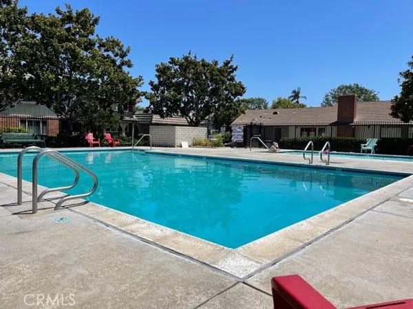 a view of a swimming pool with lawn chairs and a fire pit