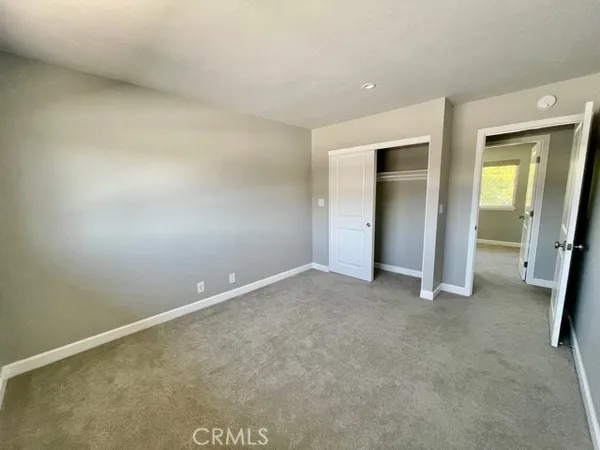an empty room with closet and mirror
