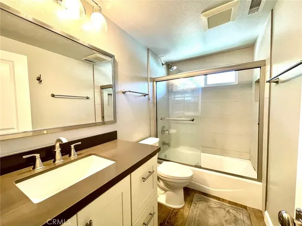 a bathroom with a sink mirror toilet and shower