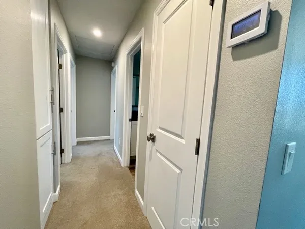 a view of a hallway with wooden shelves