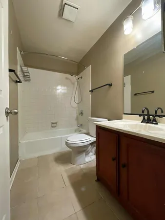a bathroom with a bathtub shower sink mirror and toilet
