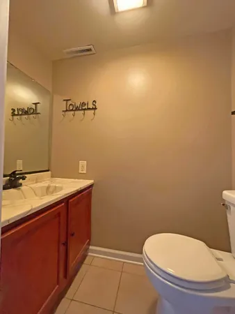 a bathroom with a granite countertop toilet and a sink