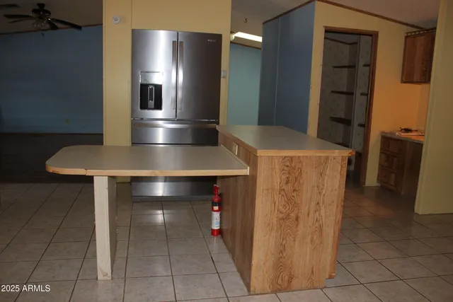 a kitchen with a sink a refrigerator and chairs